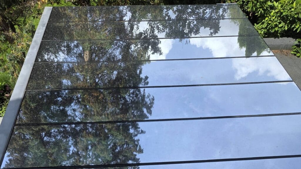 Szklany dach pokryty przezroczystą folią chłodzącą PDRC o powierzchni lustrzanej.